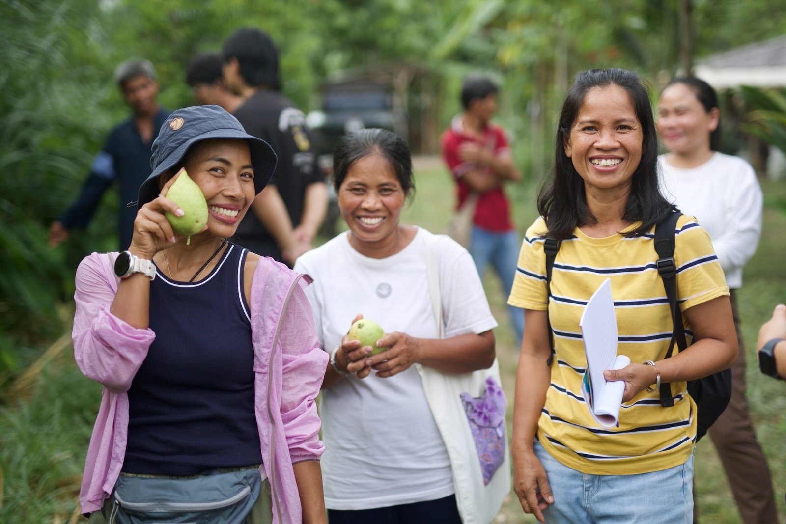 Thai women's retreat group smiling with fresh fruit at Pai Seedlings Farm