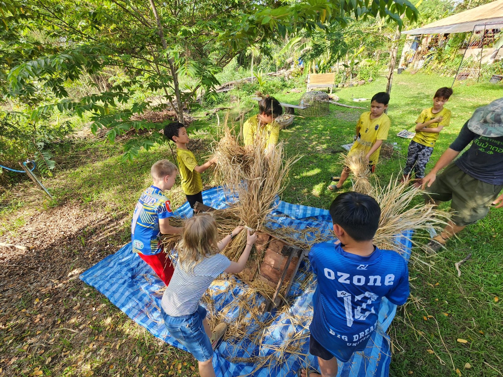 Students bundling rice straw at Pai Seedlings Farm